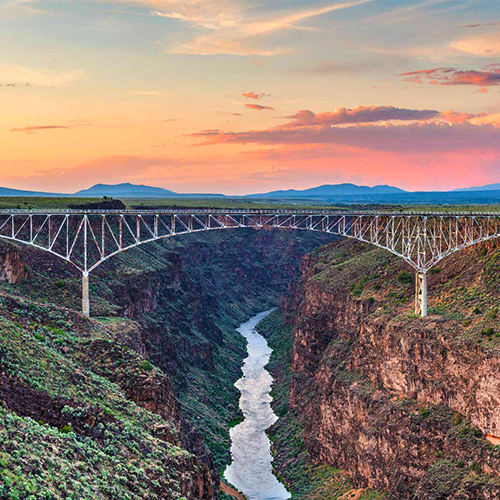 ponte cruzando o vale e o rio ao pôr do sol